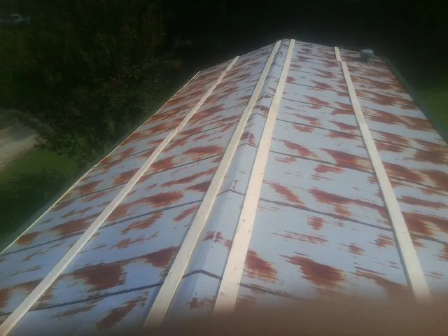 Rusted metal roof panels with new wood purlins before replacement — Storm Damage Roof Repair in Galesburg by Roofing Brothers